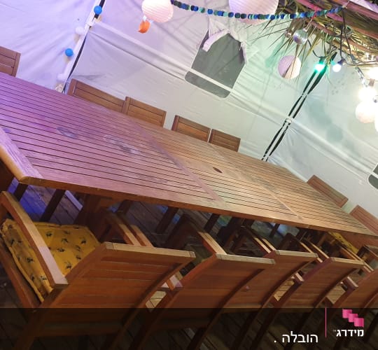 שולחן עץ גדול עם כיסאות מסביב ותאורה צבעונית